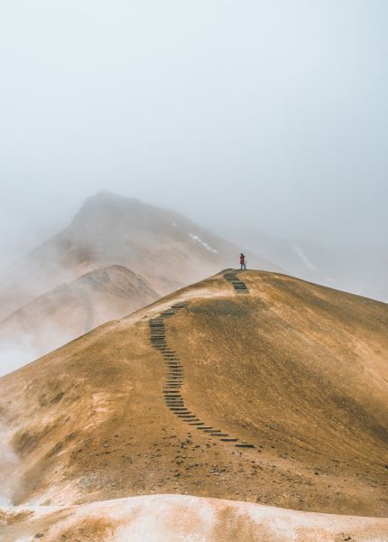 man on top brown hill